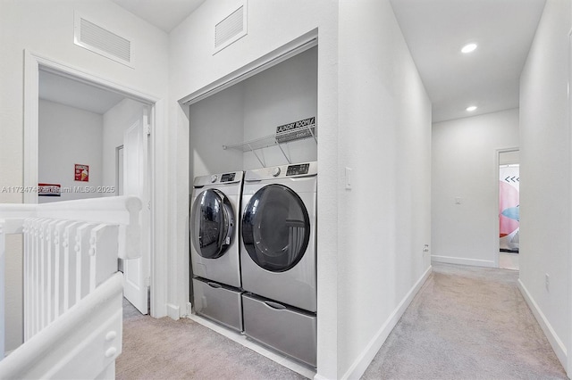 washroom with light colored carpet and washer and dryer