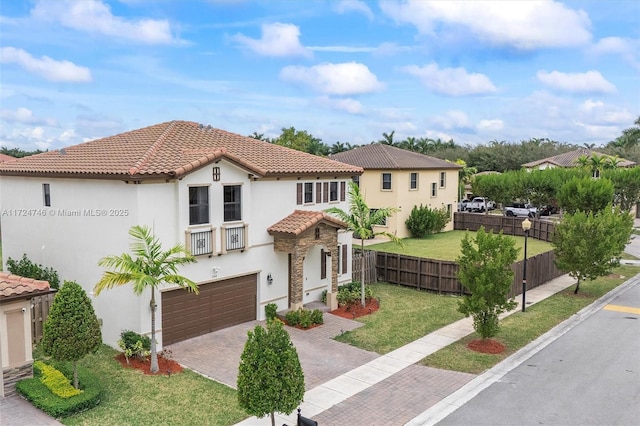 mediterranean / spanish home featuring a garage and a front yard