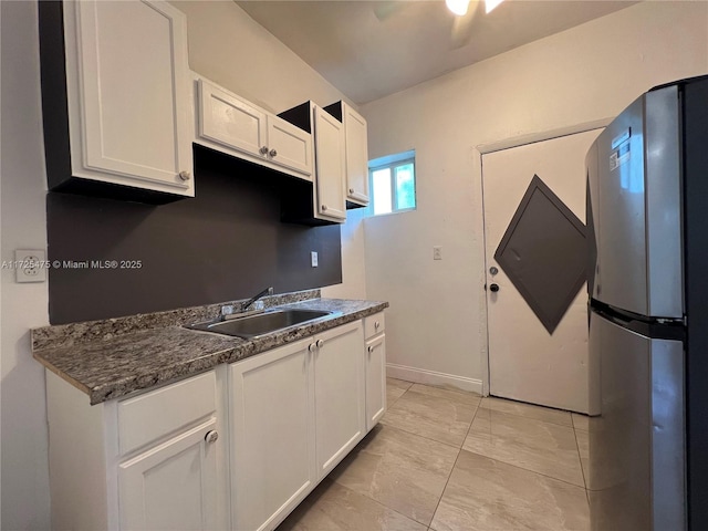 kitchen featuring sink, white cabinets, and stainless steel refrigerator