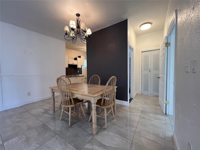 dining room with baseboards and a chandelier