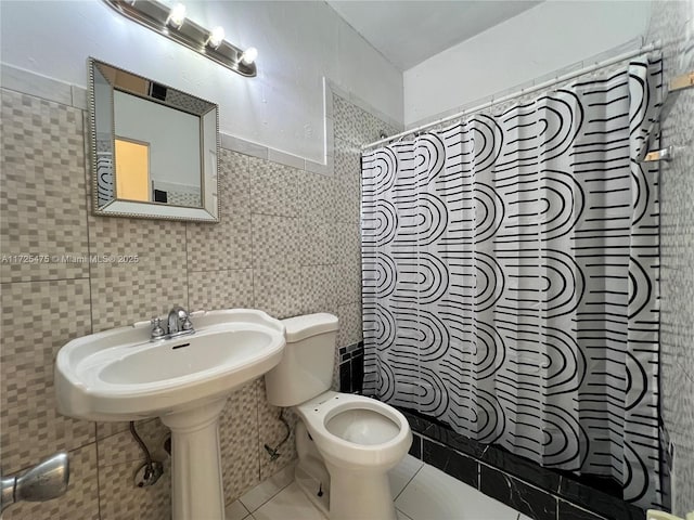 full bathroom featuring a shower with curtain, tile patterned floors, toilet, and tile walls