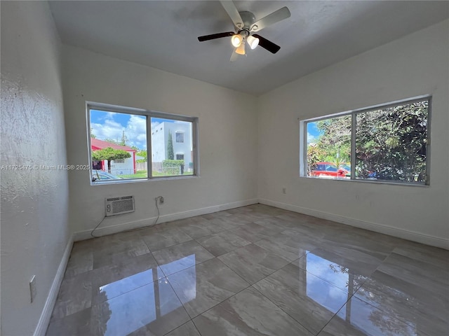 spare room with ceiling fan and an AC wall unit