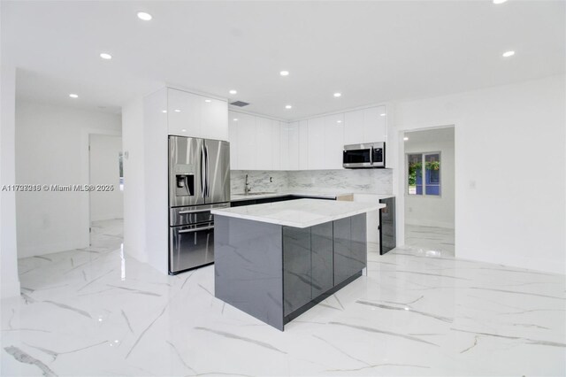 kitchen featuring stainless steel fridge with ice dispenser, decorative backsplash, a kitchen island, white cabinets, and sink