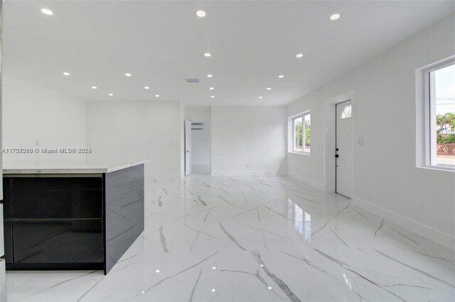 kitchen featuring white cabinets, appliances with stainless steel finishes, a center island, sink, and backsplash