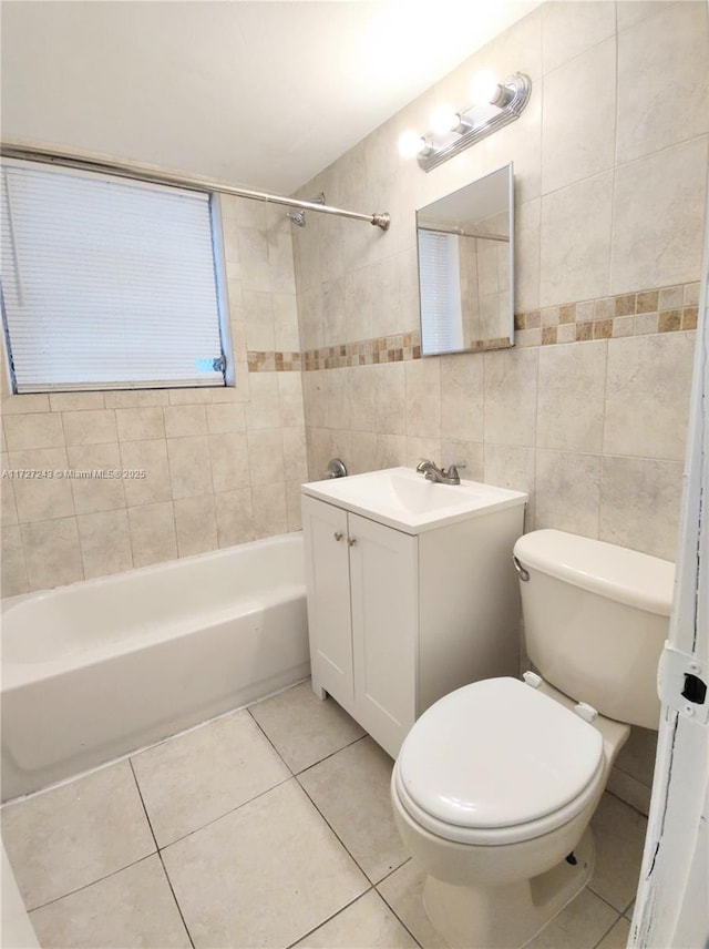 full bathroom featuring toilet, vanity, tile walls, tiled shower / bath, and tile patterned floors