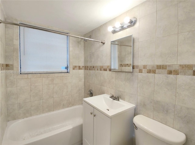 full bathroom with tile walls, toilet, vanity, and tiled shower / bath combo