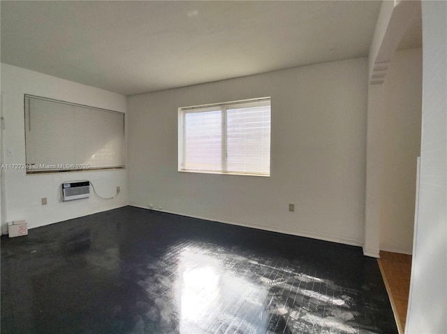 unfurnished living room featuring heating unit and a wall unit AC