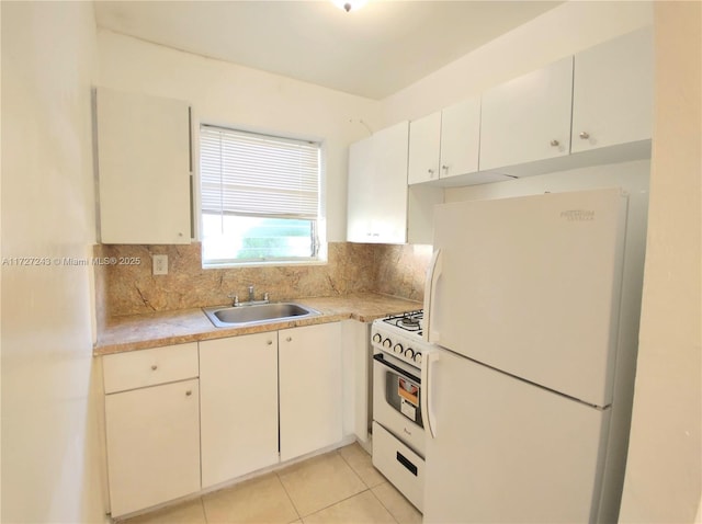 kitchen featuring white appliances, white cabinets, sink, backsplash, and light tile patterned floors