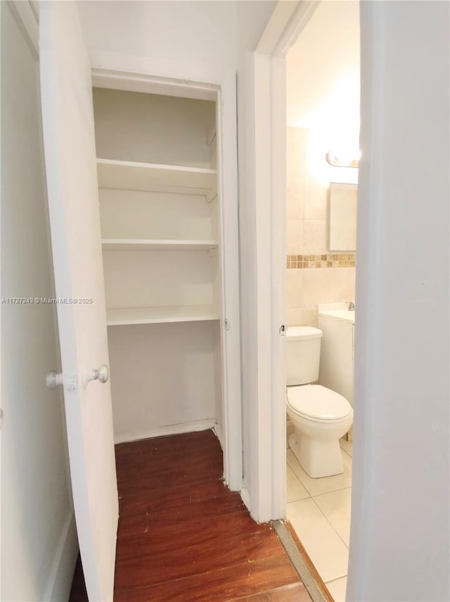 bathroom with hardwood / wood-style flooring and toilet