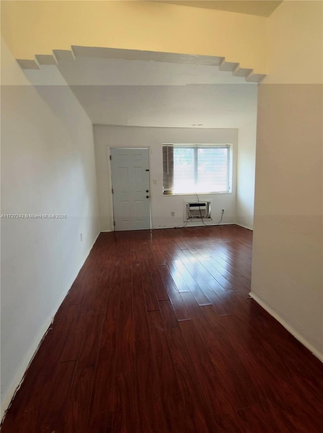 unfurnished room featuring dark hardwood / wood-style floors and an AC wall unit