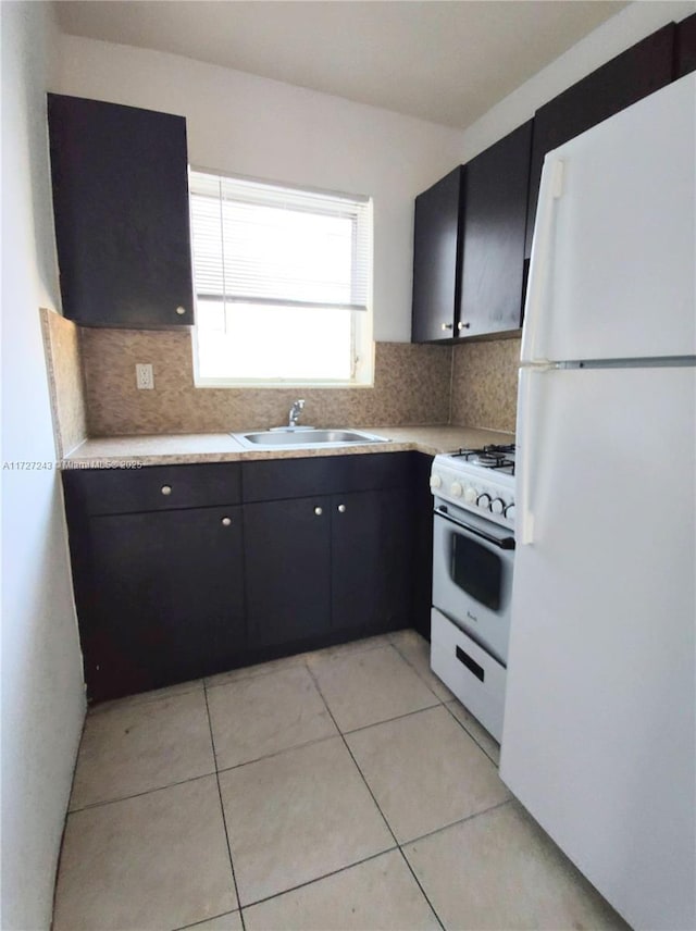 kitchen featuring light tile patterned floors, sink, tasteful backsplash, and white appliances