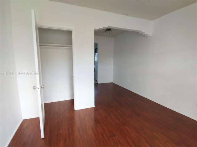 unfurnished bedroom featuring a closet and dark hardwood / wood-style flooring