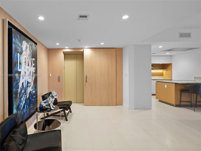 living room with elevator and wooden walls