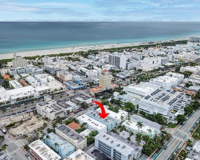 birds eye view of property featuring a water view and a beach view