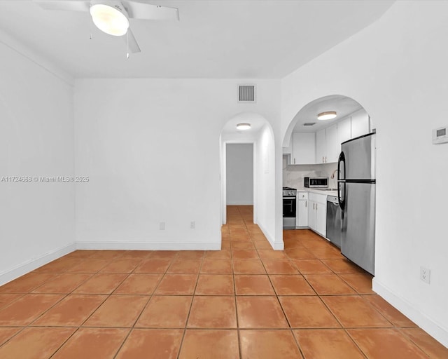 kitchen featuring ceiling fan, light tile patterned flooring, stainless steel appliances, and white cabinetry