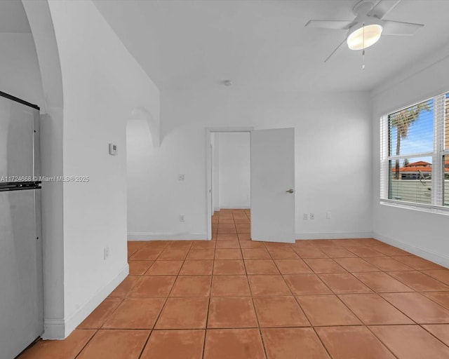 tiled spare room featuring ceiling fan