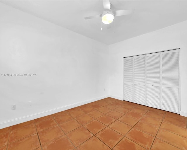 unfurnished bedroom with tile patterned floors, baseboards, a closet, and ceiling fan