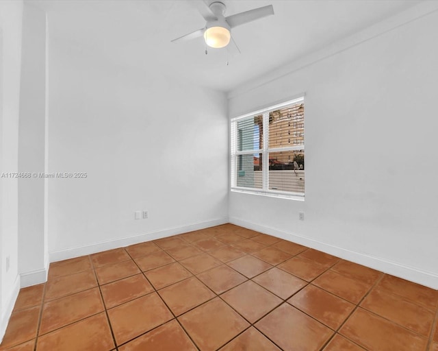 spare room featuring a ceiling fan, baseboards, and light tile patterned flooring