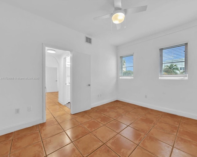 tiled empty room featuring ceiling fan