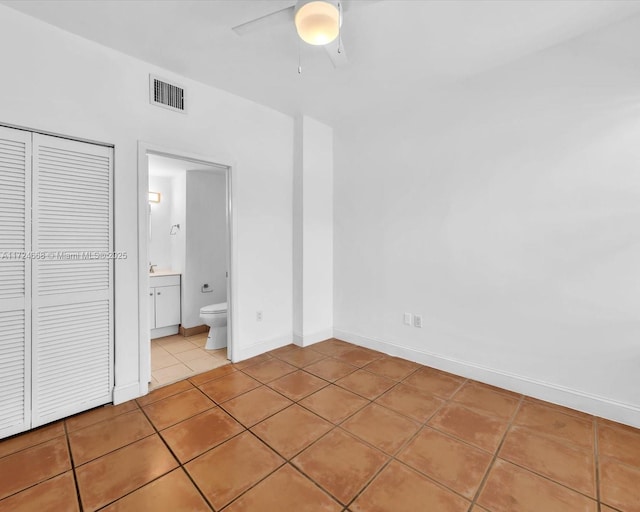 unfurnished bedroom with light tile patterned flooring, baseboards, visible vents, a closet, and ceiling fan