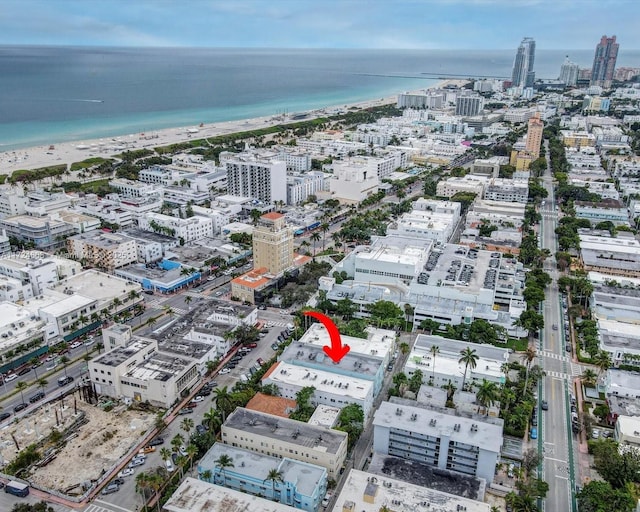 birds eye view of property featuring a water view and a beach view