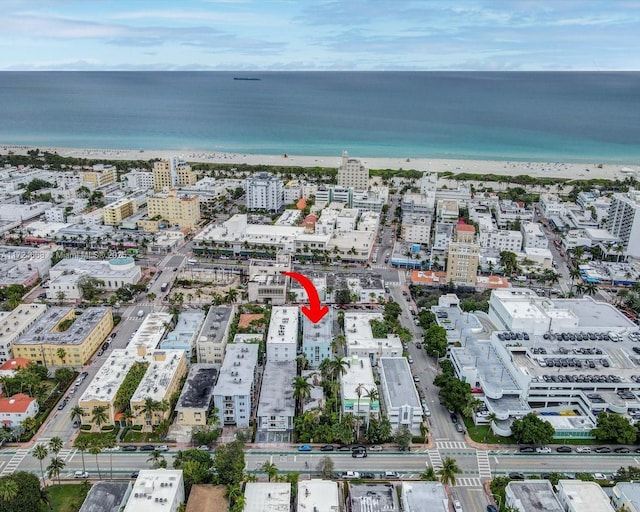 birds eye view of property with a water view and a beach view