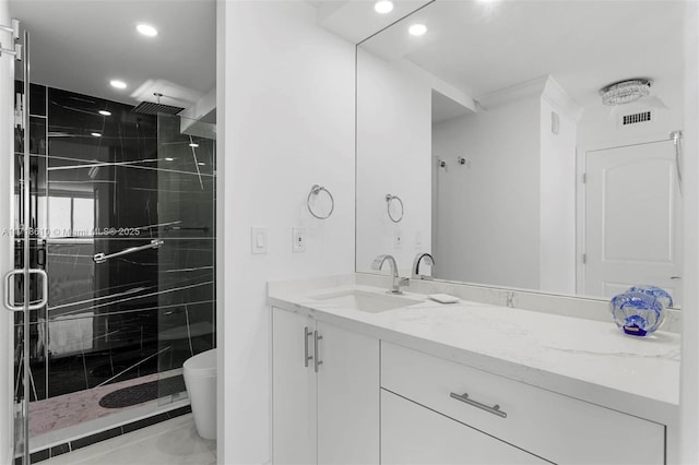 bathroom featuring toilet, vanity, and a shower with door