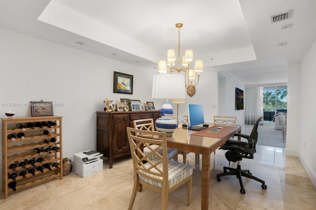 office featuring a notable chandelier and a tray ceiling