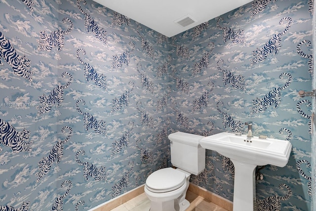 bathroom with toilet and tile patterned flooring