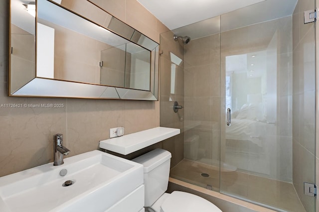 bathroom featuring a shower with shower door, sink, toilet, and tasteful backsplash