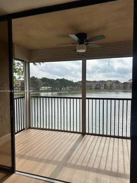 deck featuring ceiling fan and a water view