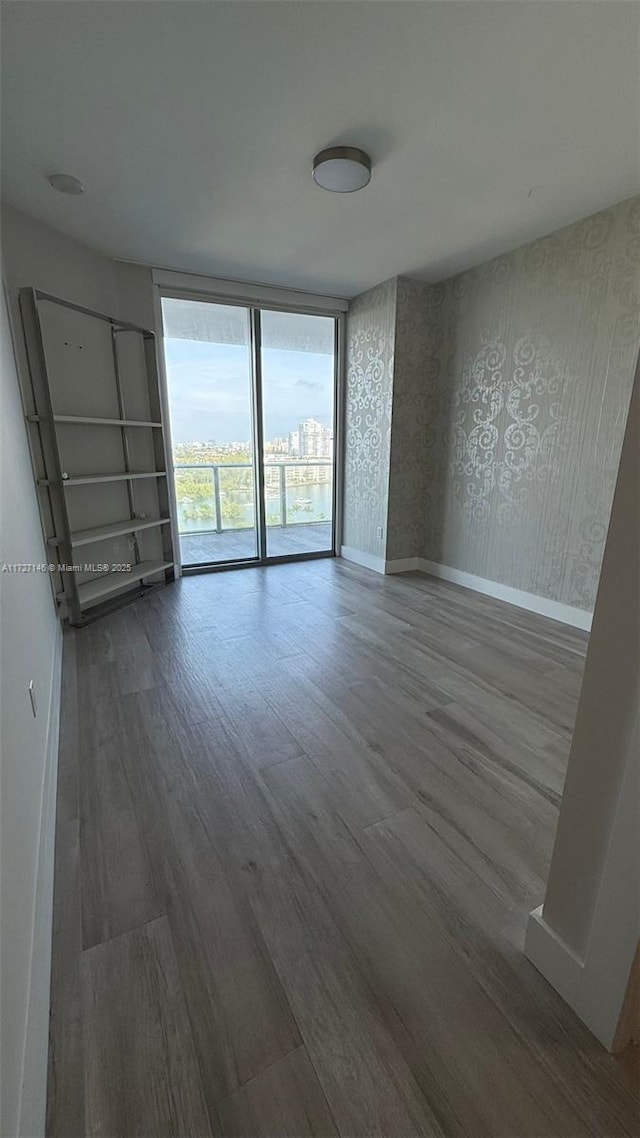 unfurnished room featuring floor to ceiling windows and wood-type flooring