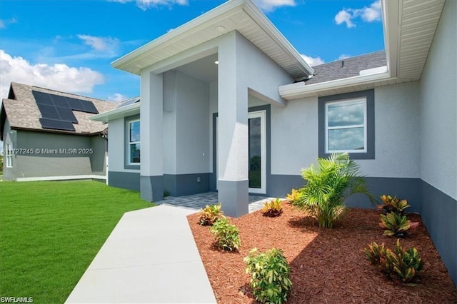 entrance to property with a lawn and solar panels