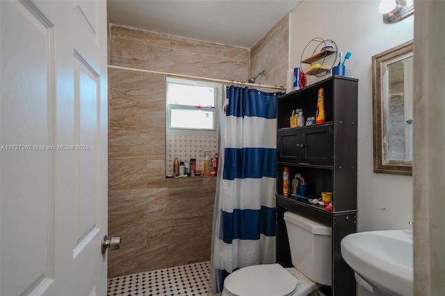 bathroom with toilet, sink, and curtained shower