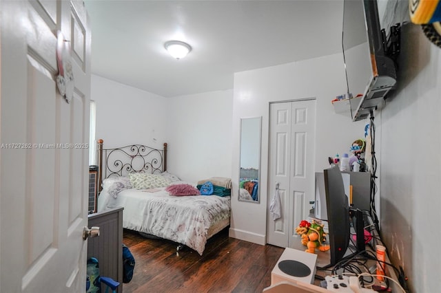 bedroom with a closet and dark hardwood / wood-style flooring