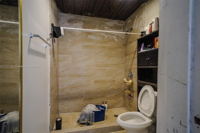 bathroom with tiled shower and toilet