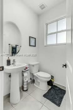 bathroom with toilet and tile patterned floors