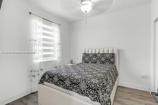 bedroom with ceiling fan and wood-type flooring