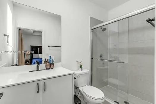 bathroom with toilet, vanity, and an enclosed shower