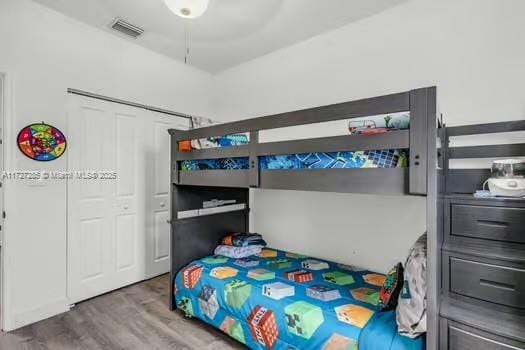 bedroom featuring ceiling fan, wood-type flooring, and a closet