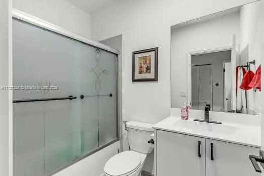 full bathroom with toilet, enclosed tub / shower combo, and vanity