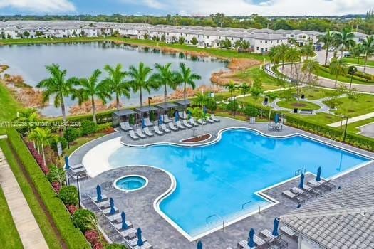 view of swimming pool featuring a patio area, a community hot tub, and a water view