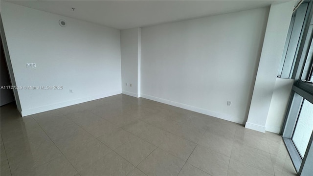 unfurnished room with light tile patterned flooring