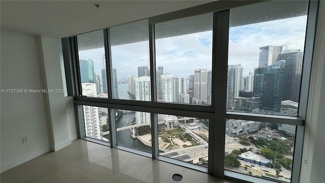 unfurnished room with plenty of natural light, tile patterned floors, and a wall of windows