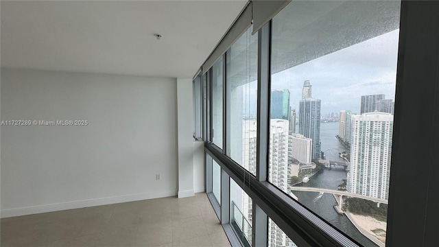 empty room with a water view, a healthy amount of sunlight, and floor to ceiling windows