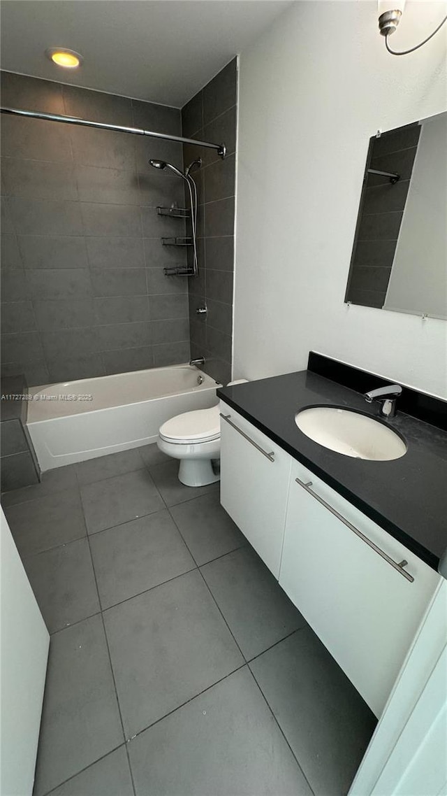 full bathroom with tile patterned floors, tiled shower / bath combo, vanity, and toilet