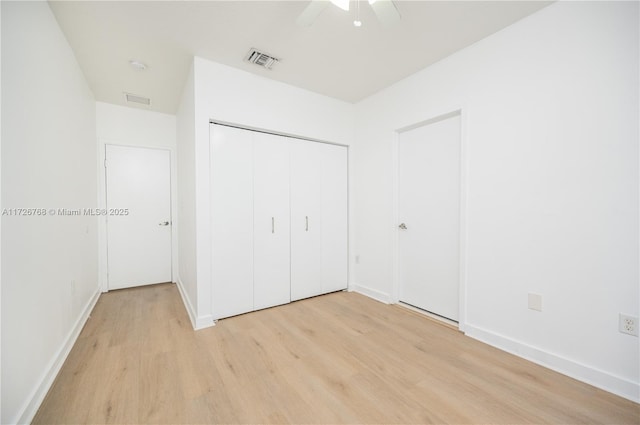 unfurnished bedroom with light wood-type flooring, ceiling fan, and a closet