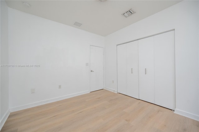 unfurnished bedroom with a closet and light hardwood / wood-style flooring