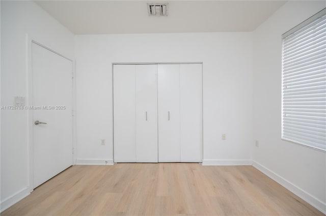 unfurnished bedroom with light hardwood / wood-style floors and a closet