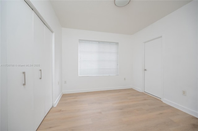 unfurnished bedroom featuring light hardwood / wood-style floors and a closet